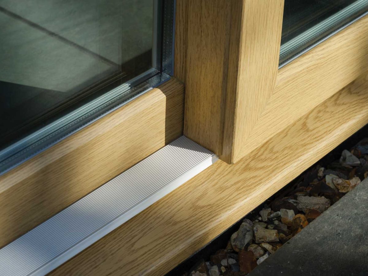 Close up of the bottom profile of light coloured woodgrain foiled upvc sliding doors