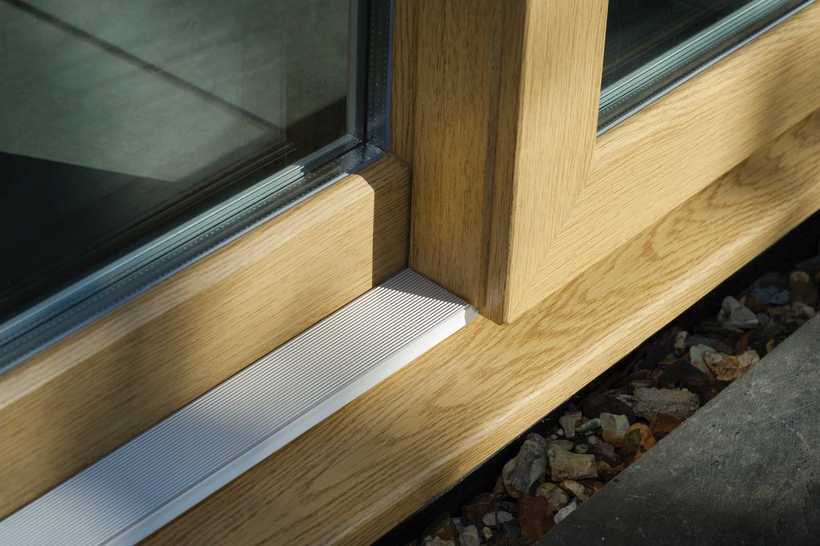 Close up of the bottom profile of light coloured woodgrain foiled upvc sliding doors