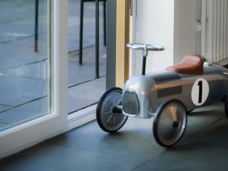 modern patio doors next to a childrens car in a kitchen