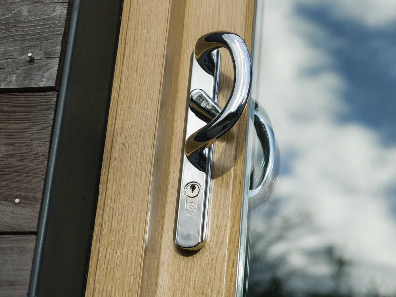 close up external shot of woodgrain foiled upvc patio sliding doors handle